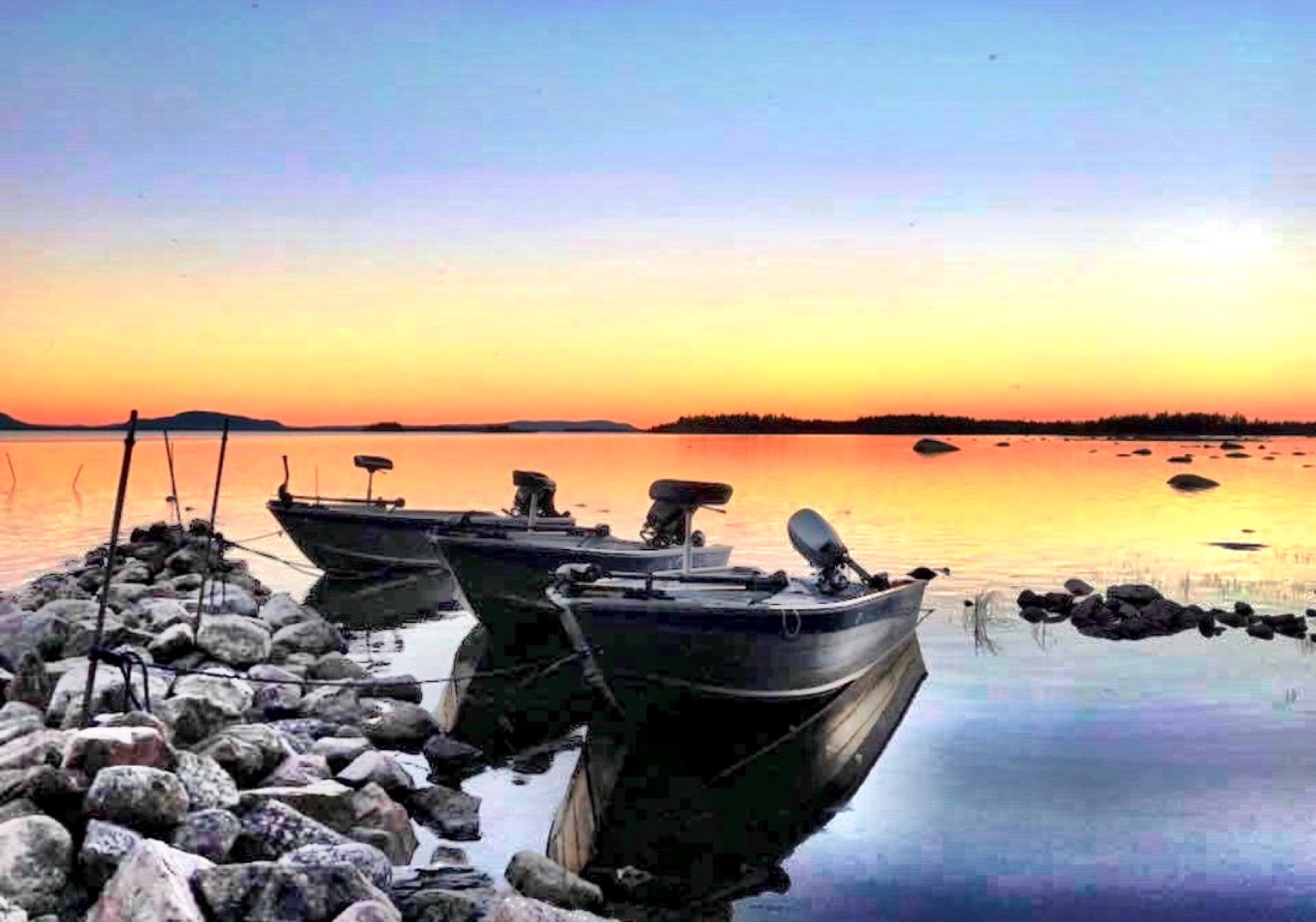 Båtar vid sjön i kvällsljus nära Wild Lake Lodge